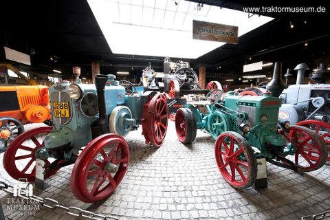 2 Oldtimertraktoren im Traktormuseum Bodensee. Der linke Traktor ist hellblau mit roten Felgen, der rechte Traktor ist türkis mit ebenfalls roten Felgen. Im Hintergrund sind weitere Oldtimer zu sehen (Copyright: Traktormuseum Bodensee)